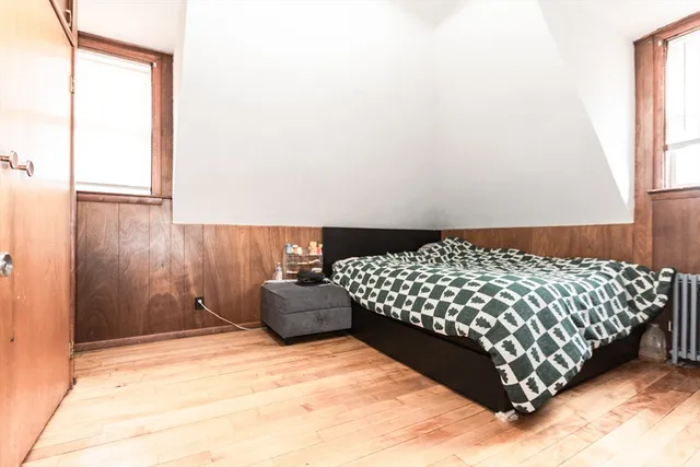 a bed sitting in a bedroom next to a window