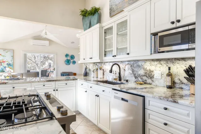 a kitchen with granite countertop a sink stove and cabinets