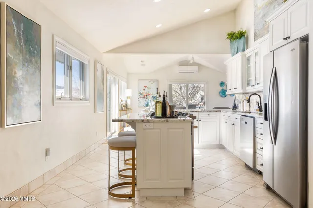 a kitchen with white cabinets and refrigerator