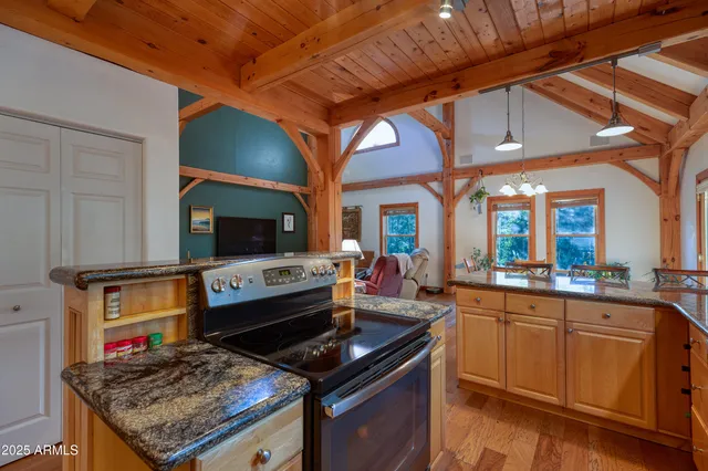 a kitchen with stainless steel appliances kitchen island granite countertop a table chairs and a refrigerator