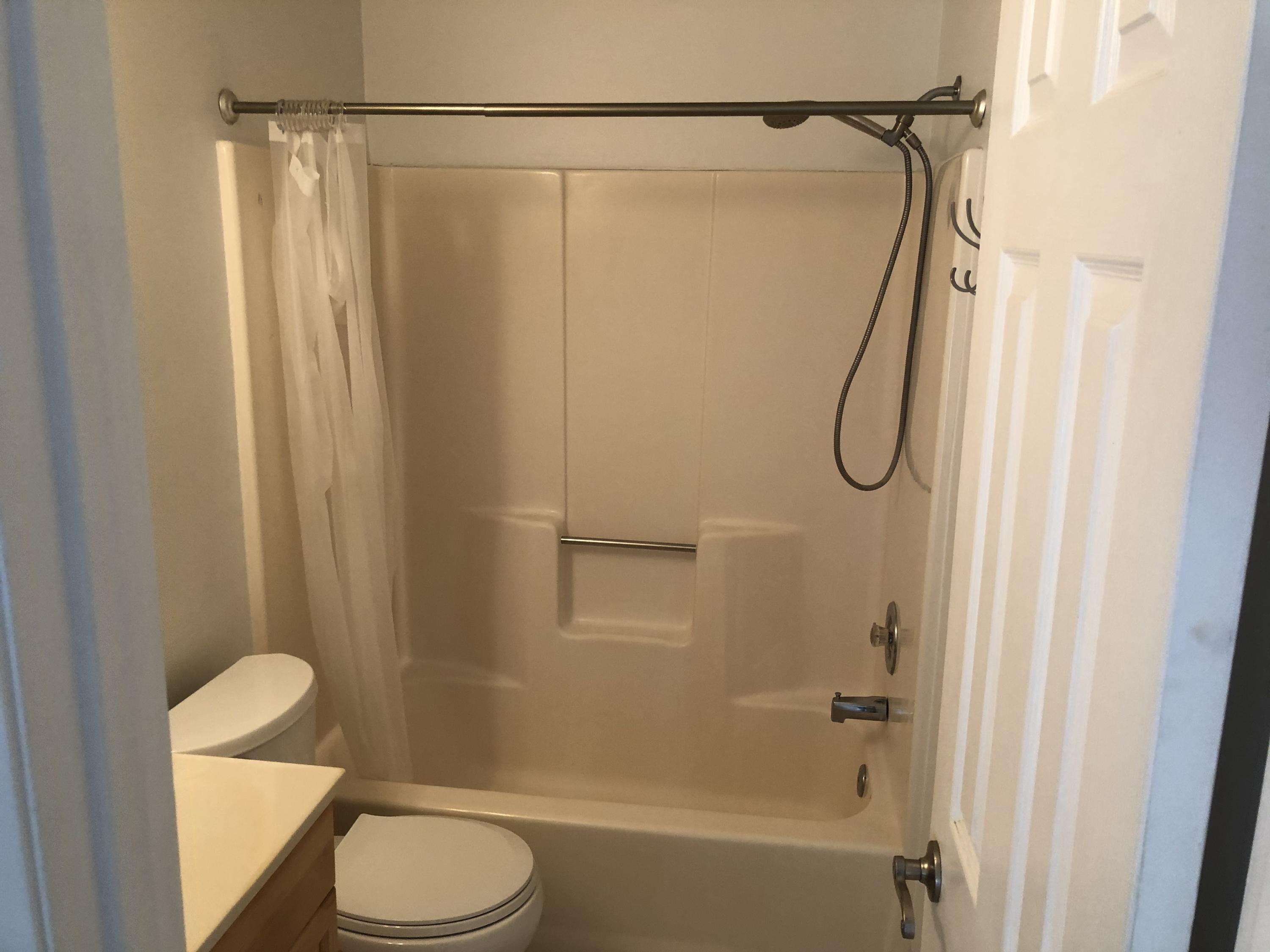 4063 Southeast Jacaranda Street Stuart, FL 34997 - Photo 13 of 15 a bathroom with a shower curtain a toilet and a shower