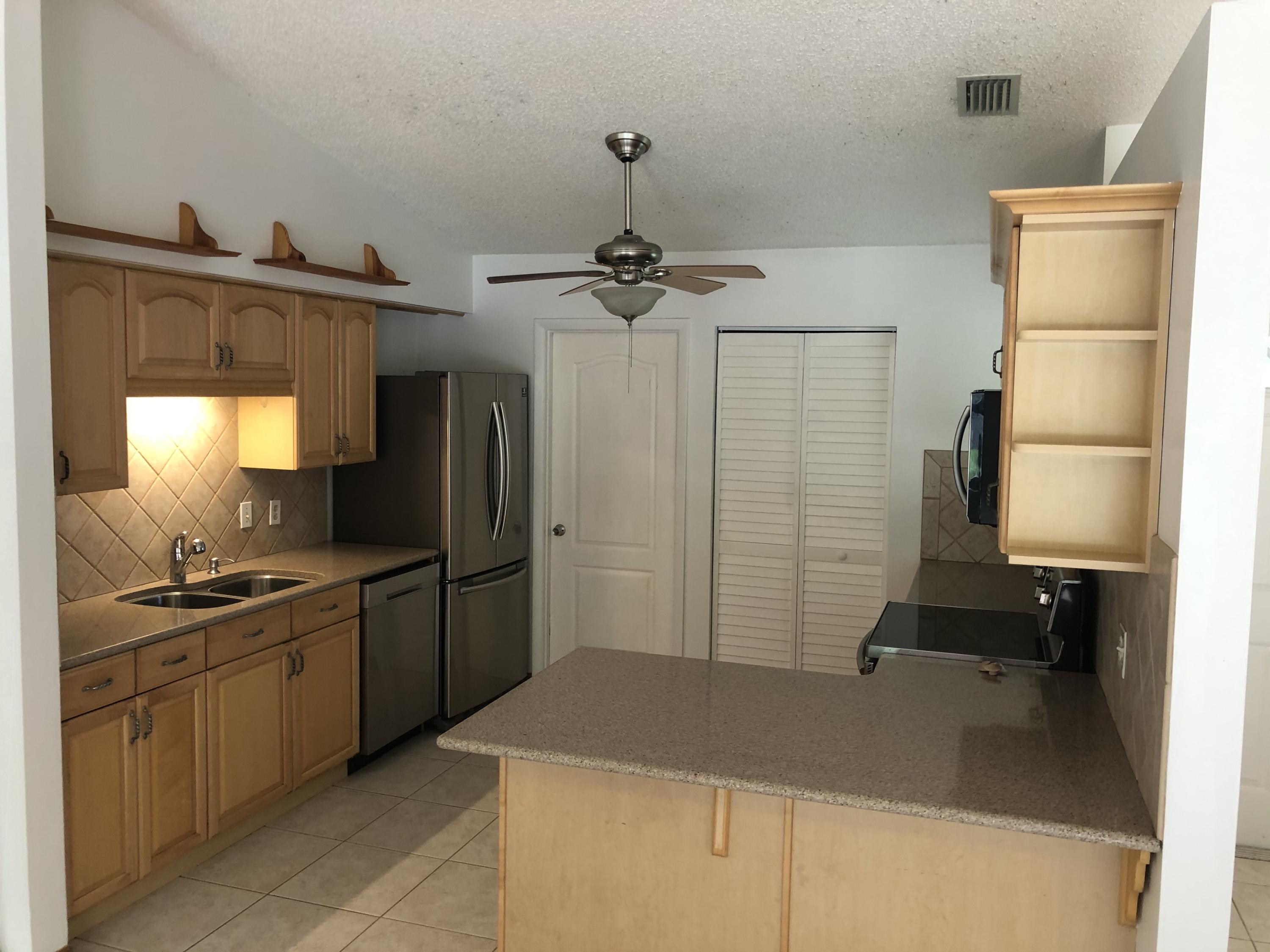 4063 Southeast Jacaranda Street Stuart, FL 34997 - Photo 3 of 15 a kitchen with a sink appliances and cabinets