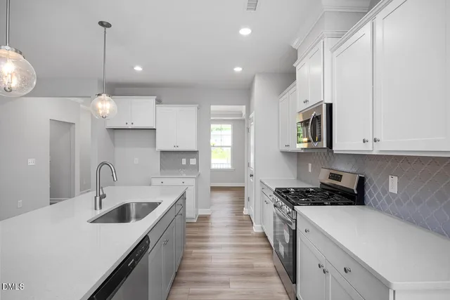 a kitchen with granite countertop a sink a counter space stainless steel appliances and cabinets