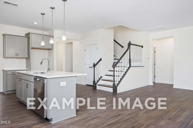 a kitchen with kitchen island a sink and wooden floors