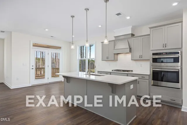 a kitchen with stainless steel appliances granite countertop a stove a sink and a wooden floors