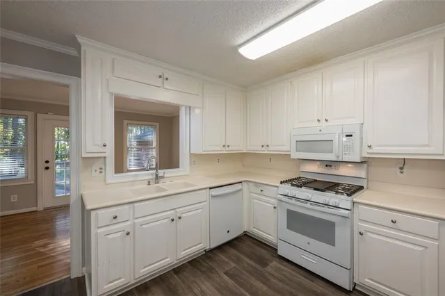 a kitchen with cabinets stainless steel appliances and a window