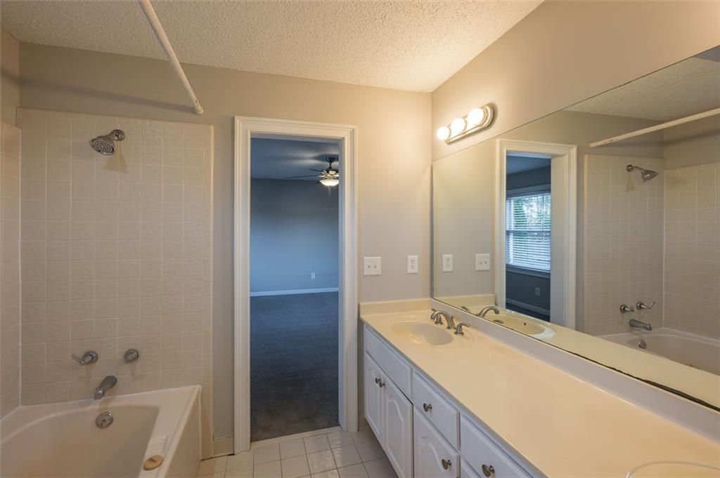 4648 Calumet Circle Northwest Duluth, GA 30096 - Photo 30 of 37 a spacious bathroom with a bathtub sink and mirror