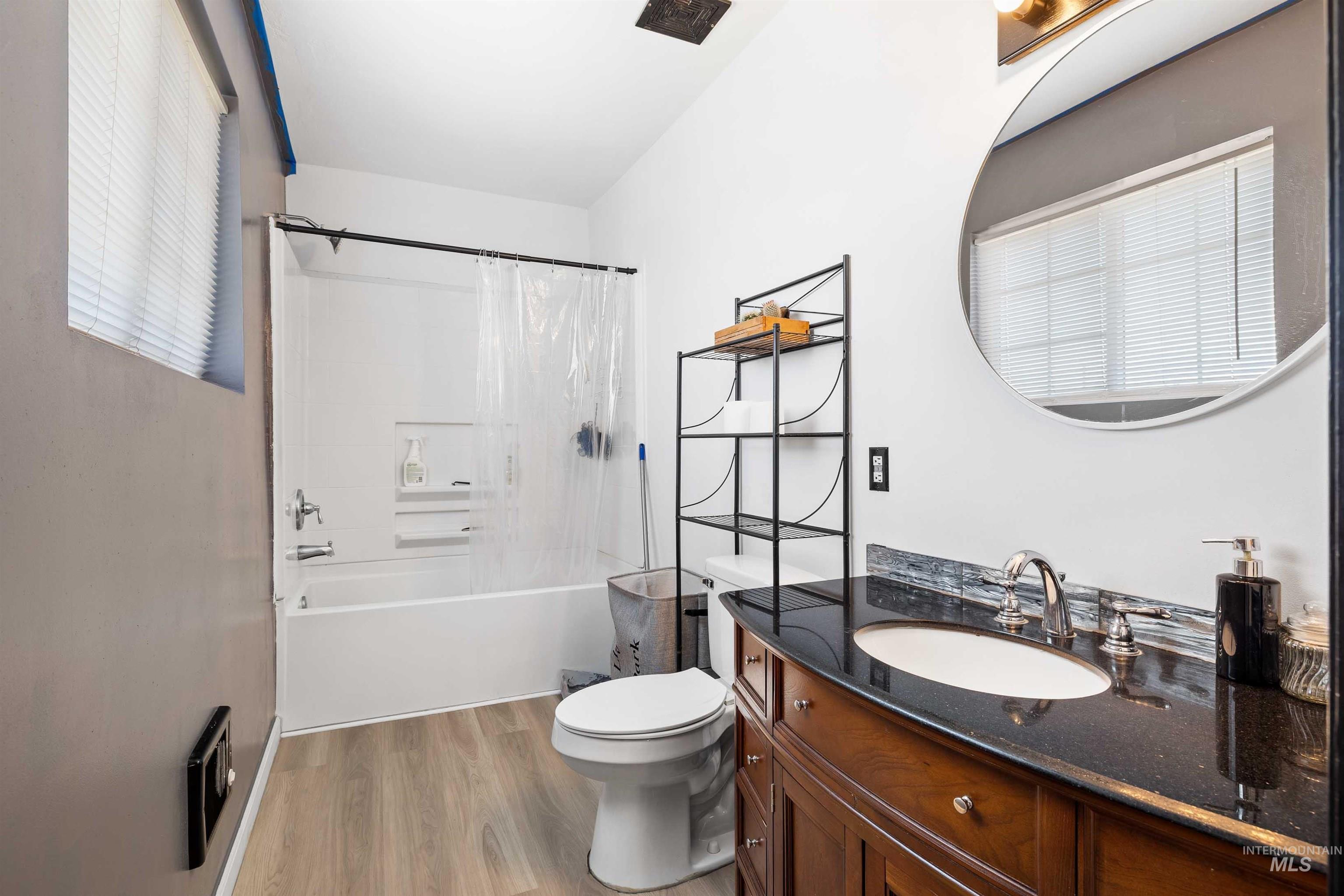 102 East 6th Street Rupert, ID 83350 - Photo 17 of 27 Bathroom featuring a dark wood-finish vanity with an undermount sink, a dark speckled countertop, and a tiled backsplash