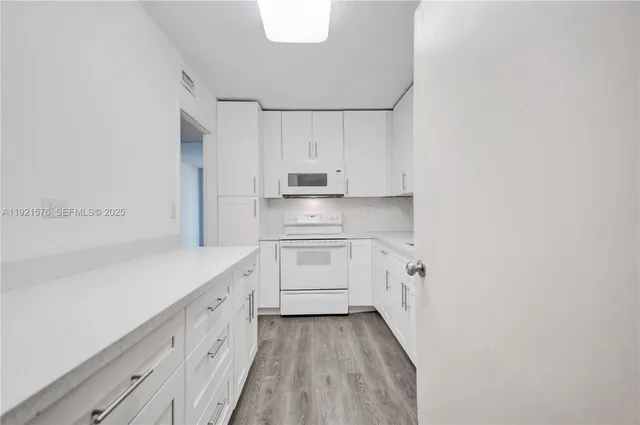 a kitchen with white cabinets and white appliances