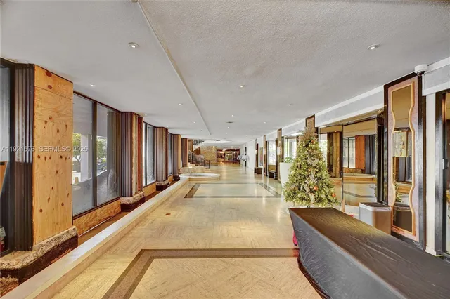 a view of living room filled with furniture and large windows