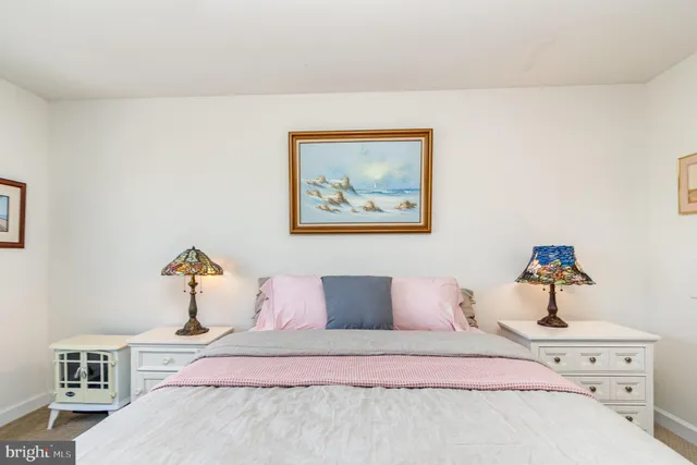 a bedroom with a bed and painting on the wall