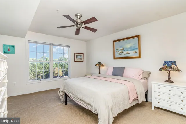 a bedroom with a bed a window and a chandelier
