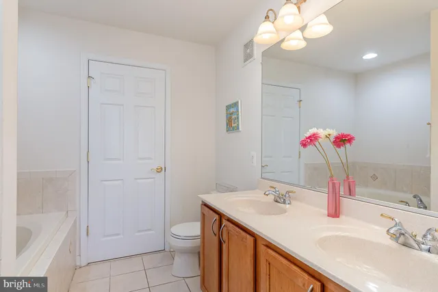 a bathroom with a sink vanity tub and shower