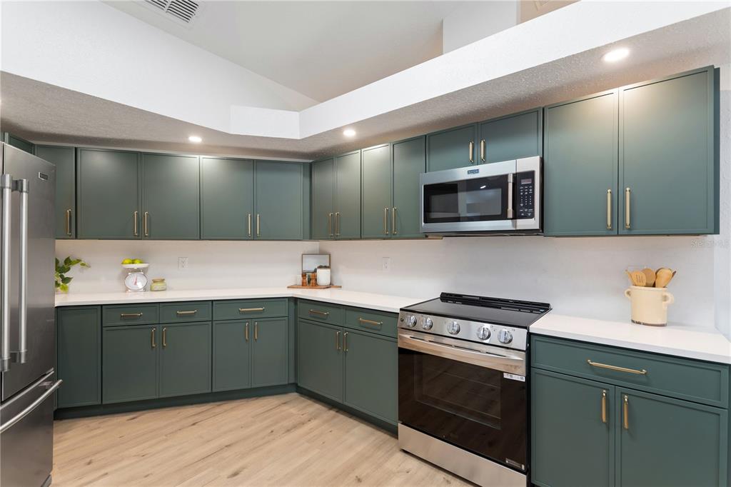 419 Silas Court Spring Hill, FL 34609 - Photo 12 of 56 a kitchen with a sink and a stove top oven with wooden floor
