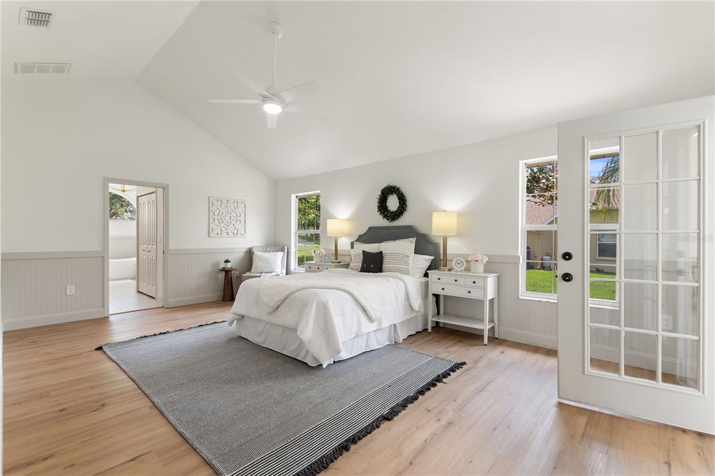 419 Silas Court Spring Hill, FL 34609 - Photo 25 of 56 a bedroom with a large bed and a wooden floor