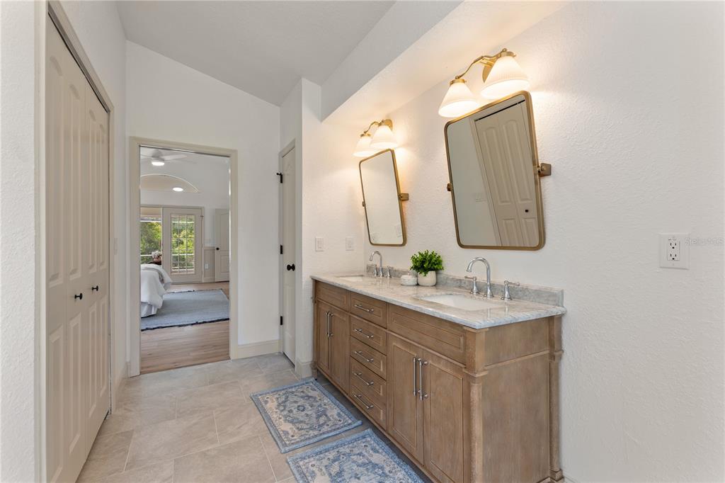 419 Silas Court Spring Hill, FL 34609 - Photo 30 of 56 a en suite bathroom with a double vanity sink and a mirror