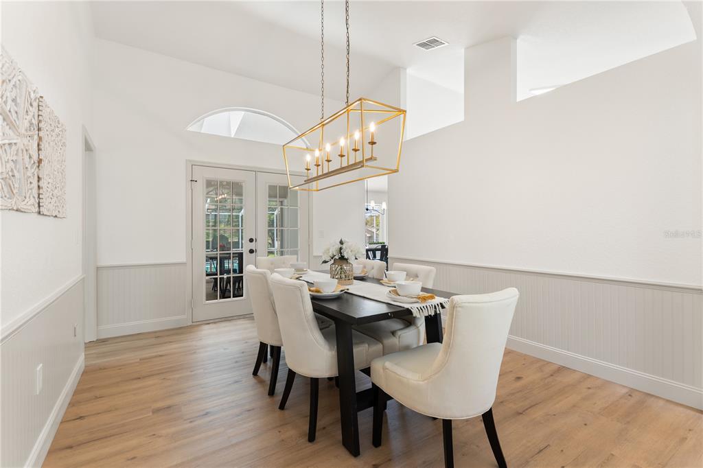 419 Silas Court Spring Hill, FL 34609 - Photo 10 of 56 a view of a dining room with furniture a chandelier and wooden floor