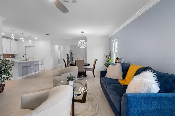 a living room with furniture and a view of kitchen