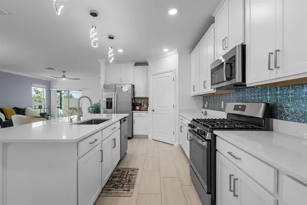 a large kitchen with stainless steel appliances granite countertop a lot of counter space sink and cabinets