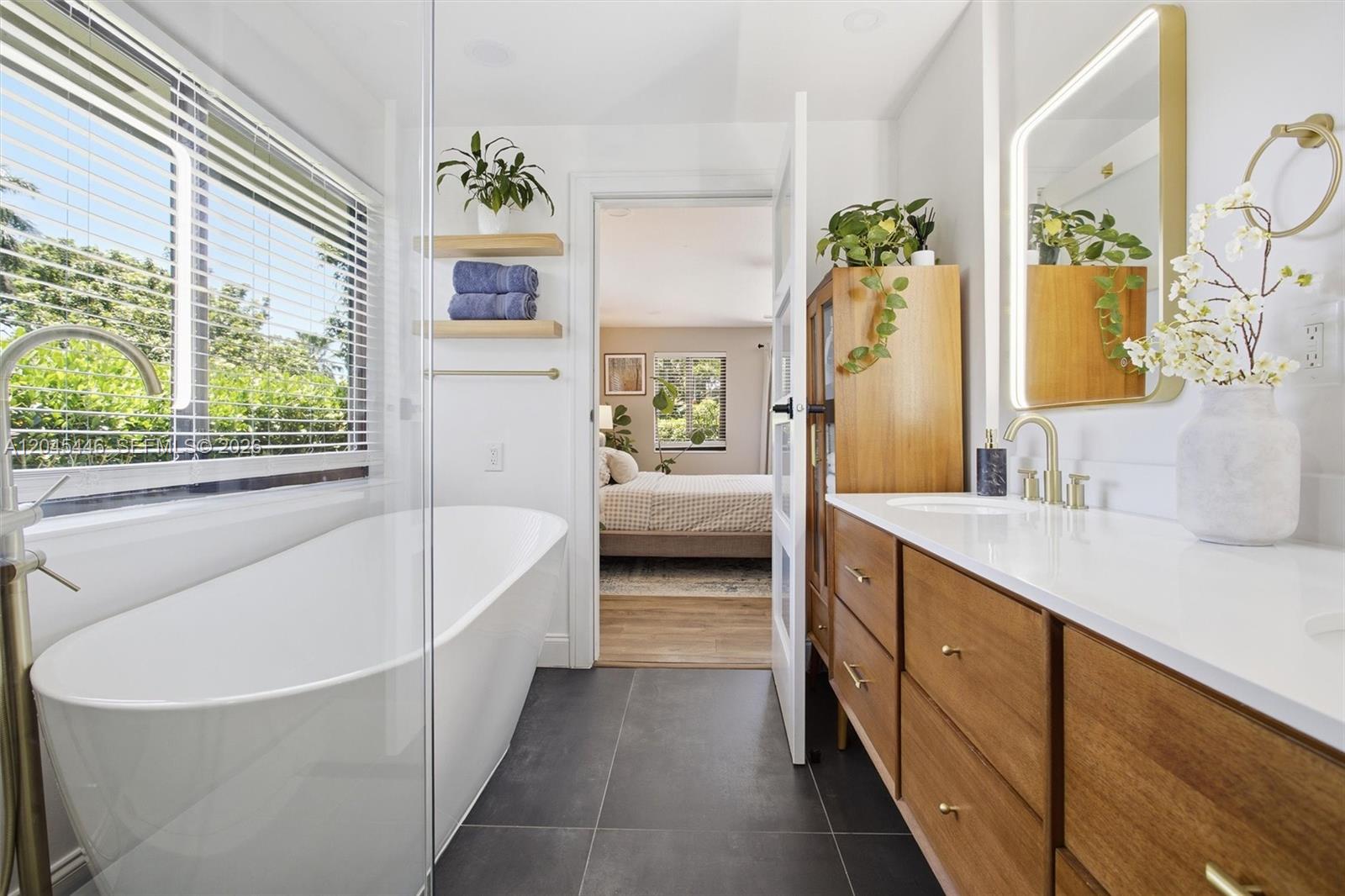 8440 Southwest 180th Street Palmetto Bay, FL 33157 - Photo 27 of 54 a spacious en suite bathroom with a granite countertop tub and a large window