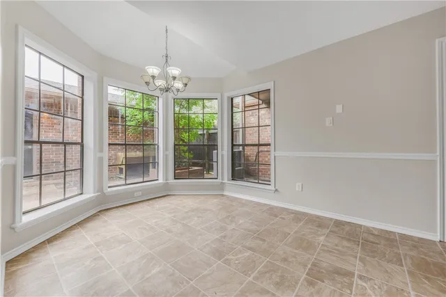 en empty room with windows and chandelier