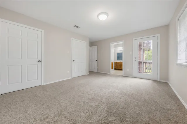a view of empty room with wooden floor and window