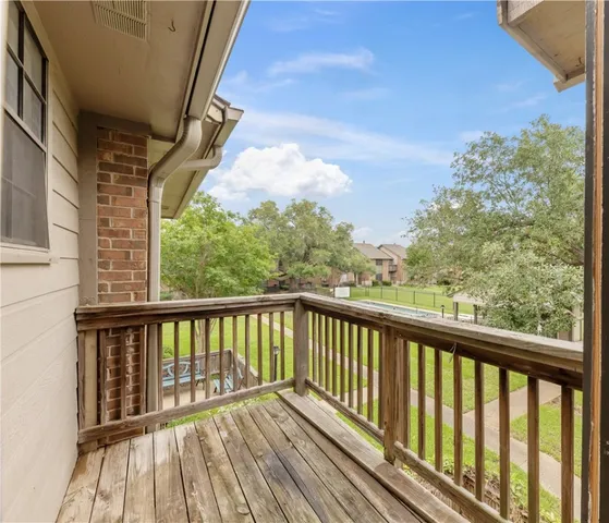 a view of balcony with wooden floor and fence