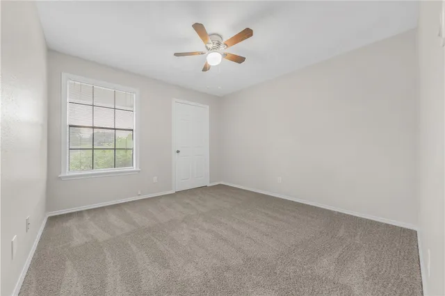 an empty room with closet and windows