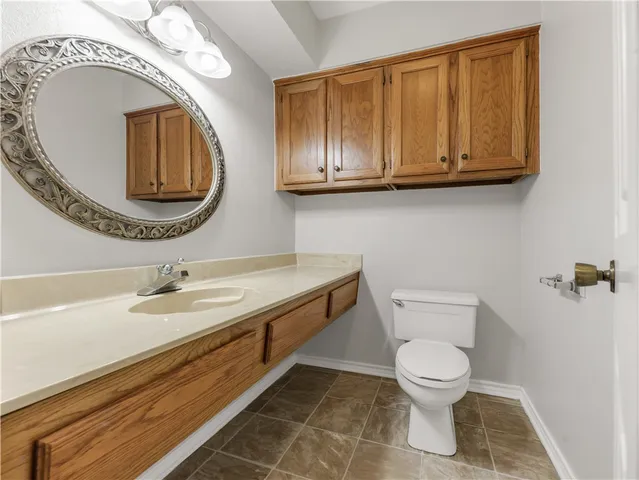 a bathroom with a toilet a sink and mirror