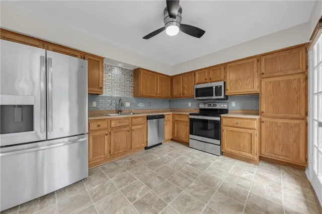 a kitchen with white cabinets stainless steel appliances and a window