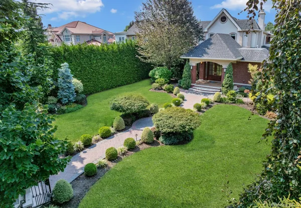 a front view of a house with a yard and fountain