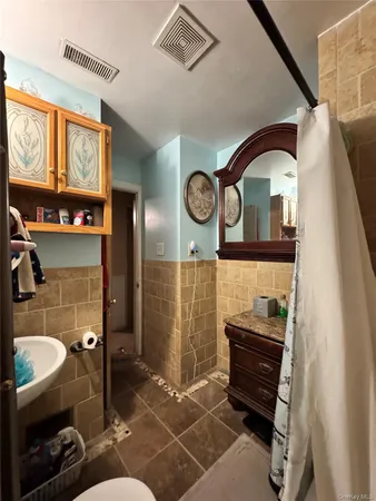 a bathroom with a toilet a sink and a mirror