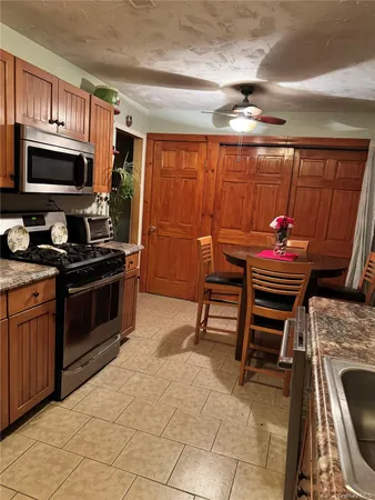 a kitchen with stainless steel appliances kitchen island granite countertop a stove a sink and a microwave