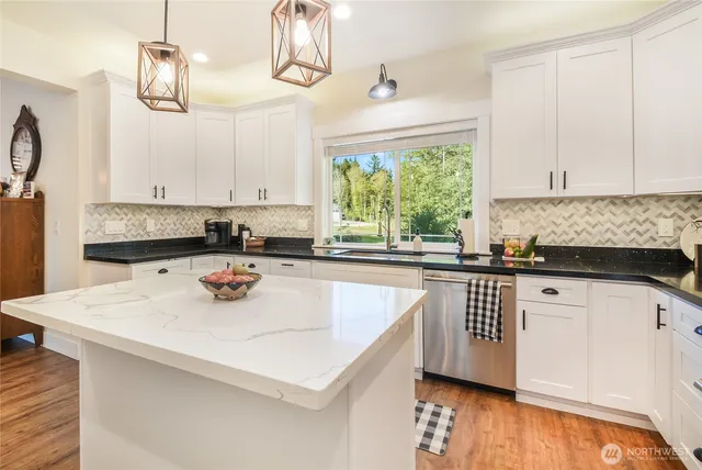 a kitchen with a sink a window and cabinets