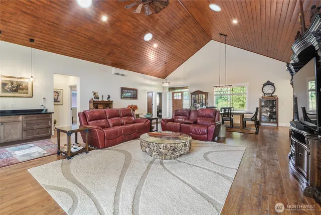 a large bedroom with furniture a large window and wooden floor