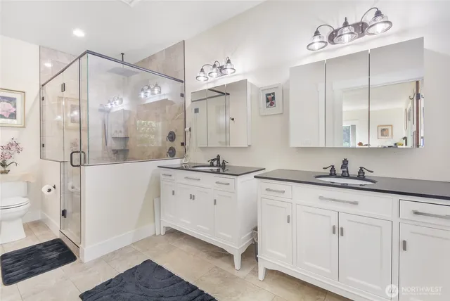 a spacious bathroom with a granite countertop sink mirror and a shower