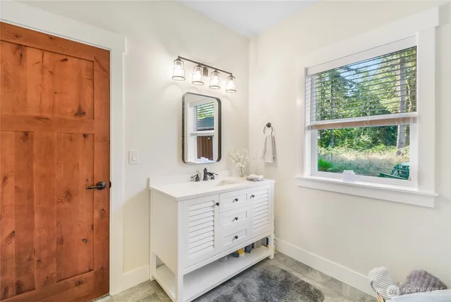 a bathroom with a double vanity sink a mirror and a shower