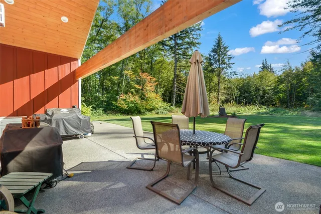 a view of a patio with a table chairs and a backyard
