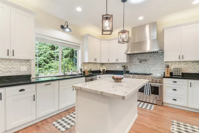 a kitchen with a stove a sink a center island and cabinets