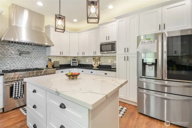 a kitchen with kitchen island a sink appliances and cabinets
