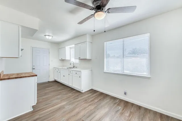 a kitchen with a sink cabinets and wooden floor