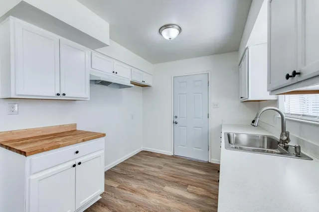 a kitchen with granite countertop a sink and dishwasher a stove top oven
