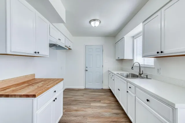 a kitchen with granite countertop white cabinets and stainless steel appliances