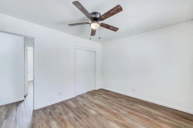 an empty room with a window and a ceiling fan