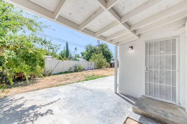 a view of a backyard with potted plants and wooden fence