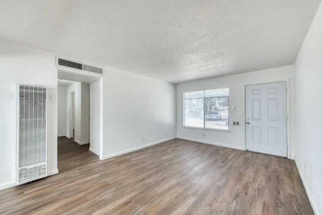 an empty room with wooden floor and a window