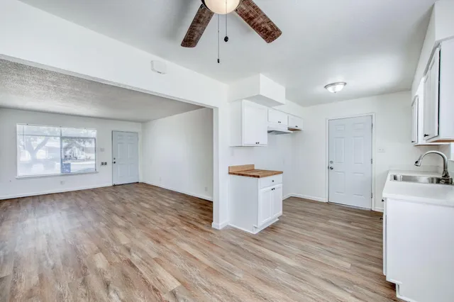 a view of a kitchen with wooden floor and a sink