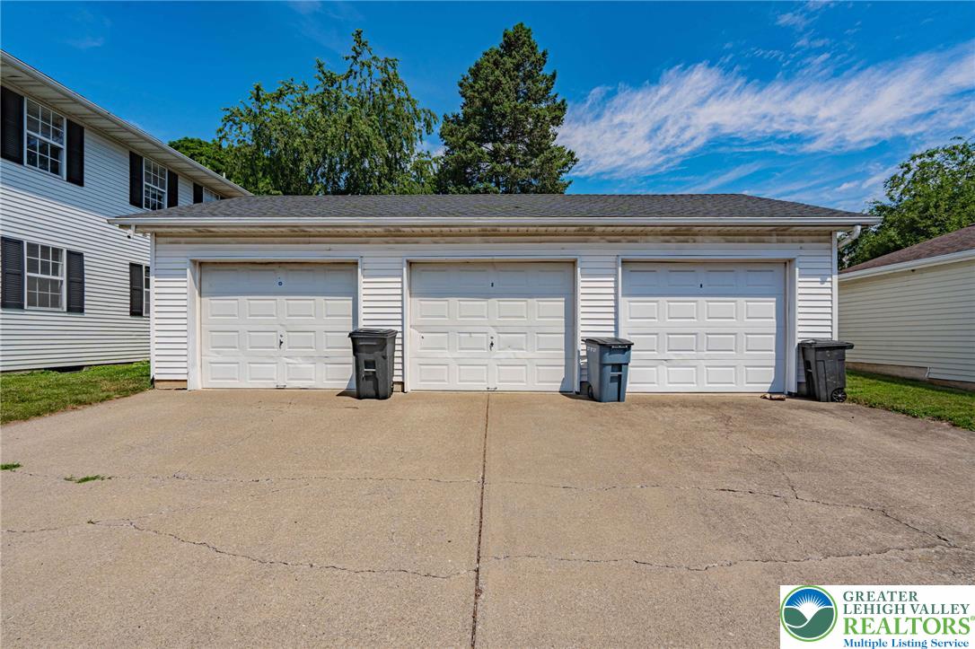 25 North 8th Street Emmaus, PA 18049 - Photo 48 of 51 Three pristine garage doors offer ample parking and storage, complementing the siding and blue skies.