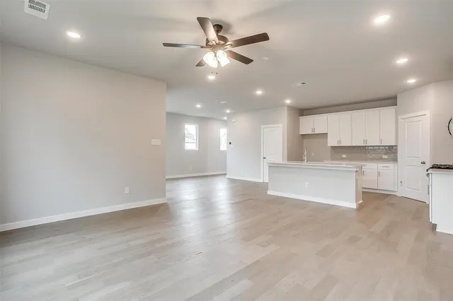 a view of kitchen with kitchen island stainless steel appliances cabinets a sink and a counter top space