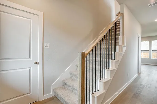a view of an empty room with kitchen appliances and a ceiling fan